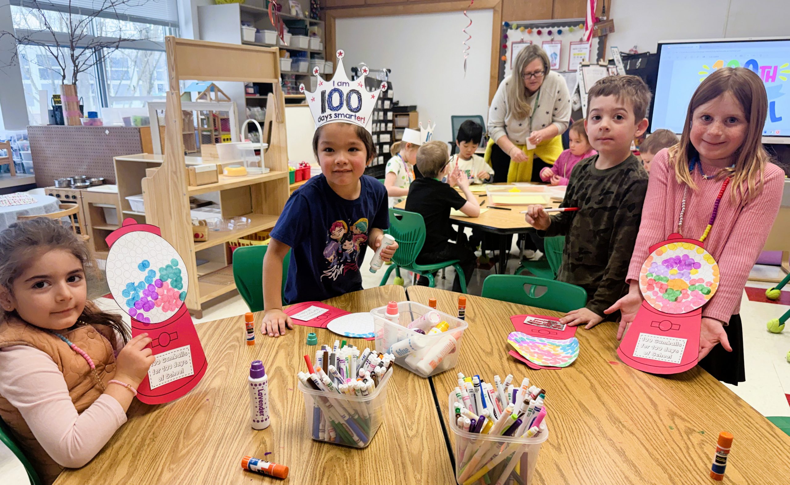 Students sit at table wearing 100 days of school hats.