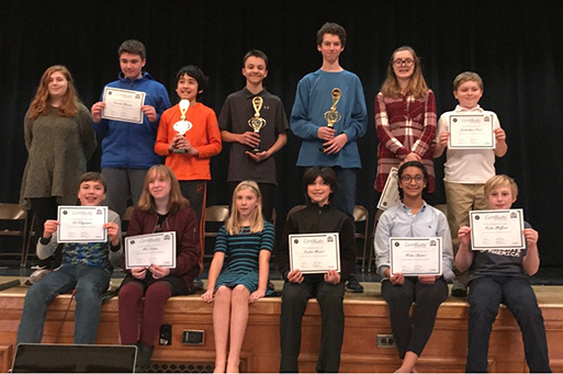 group photo of geography Bee participants holding certificates and trophies.