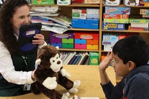 This is an image of a student working with a teacher and a Bluebees pal.