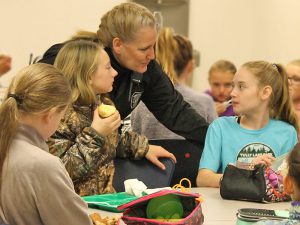 This is an image of Officer Beth Brainard chatting with students during lunch