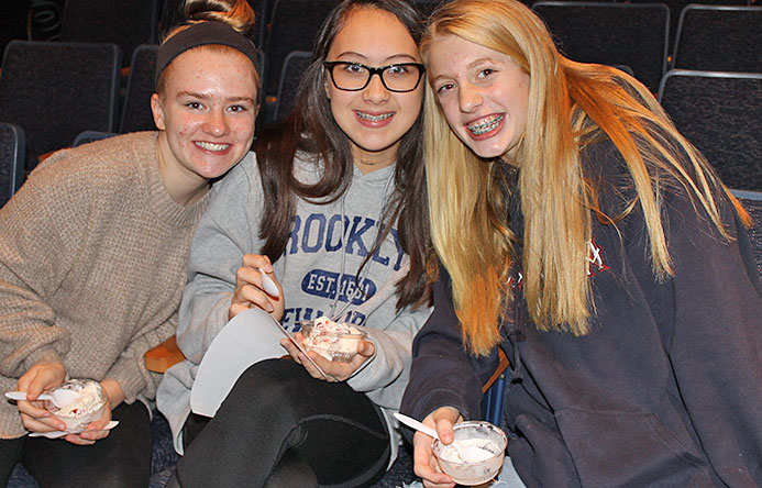 This is an image of three girls eating ice cream and smiling