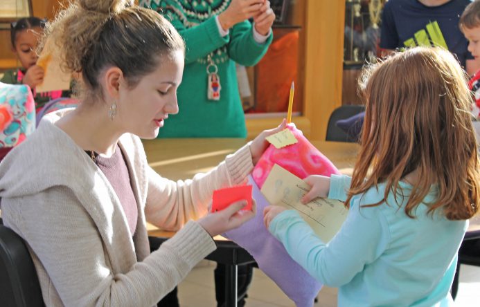 This is an image of a young student receiving a memory book from an older student