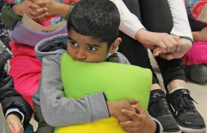 This is an image of a male student holding a pillow