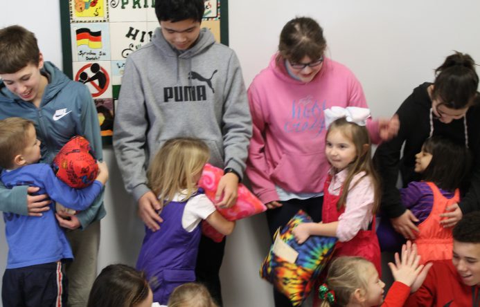 This is an image of several younger students hugging their older buddies