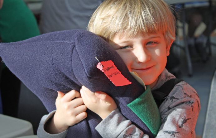 This is an image of a male student hugging a pillow