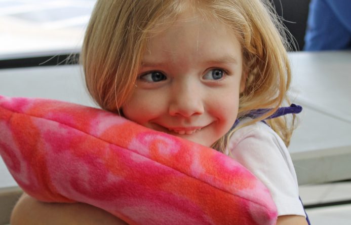 This is an image of a female student hugging a pillow