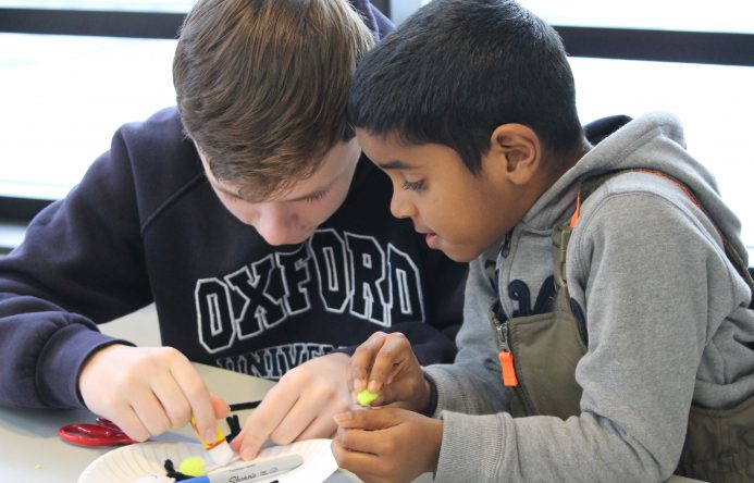 This is an image of two students working closely on a project