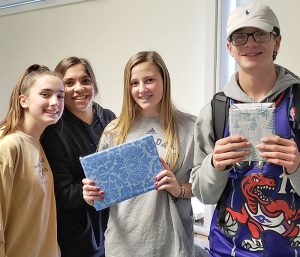 This is an image of four F-M students holding gifts and smiling