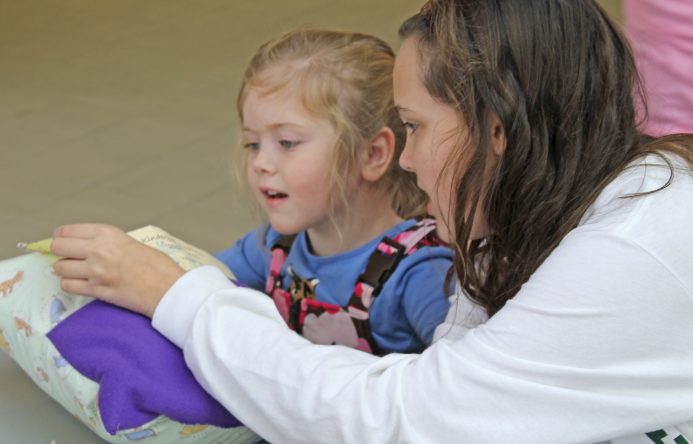 This is an image of two students reading a book together