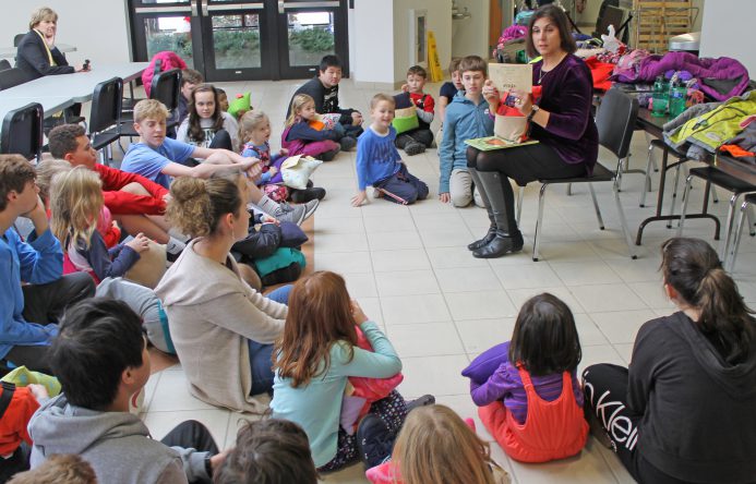 This is an image of Mrs. Brenner reading a book to students