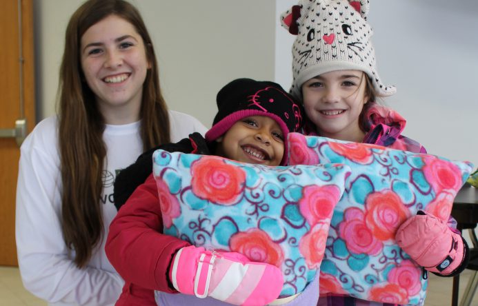 This is an image of three students standing together and smiling