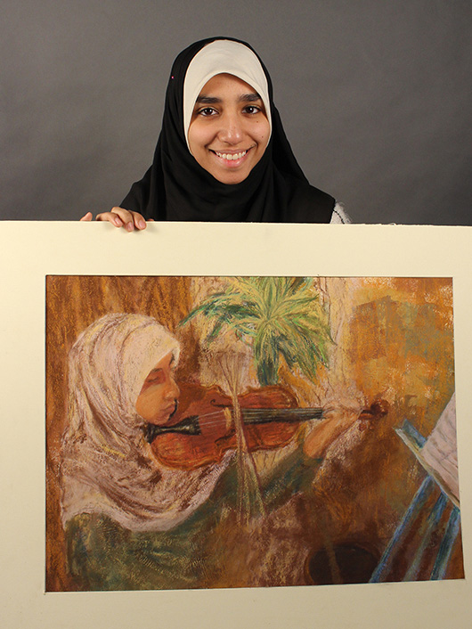 This is an image of an F-M student holding her artwork