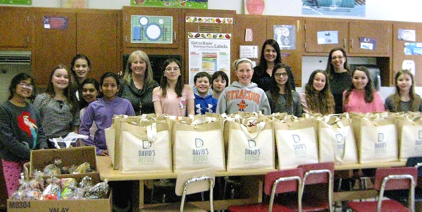 This is an image of students standing with hospitality bags that they prepared for David's Refuge