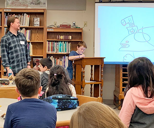 This is an image of author Nathan Hale working with a student