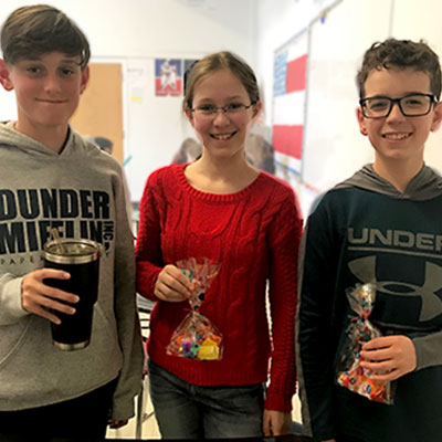 This is an image of three students holding treat bags