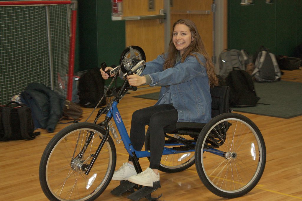 A female student uses an adapted bicycle.