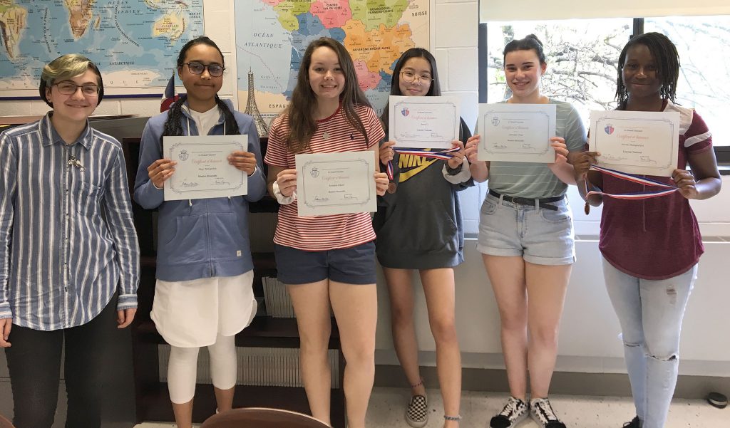 This is a group of students standing and holding paper certificates. 
