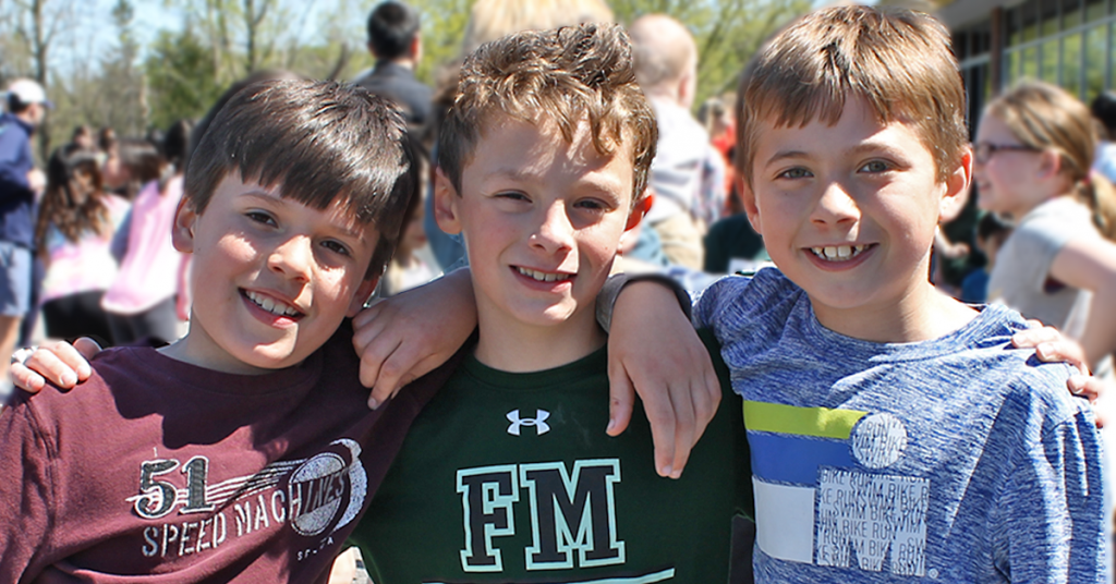 This is a photo of three students smiling for the camera