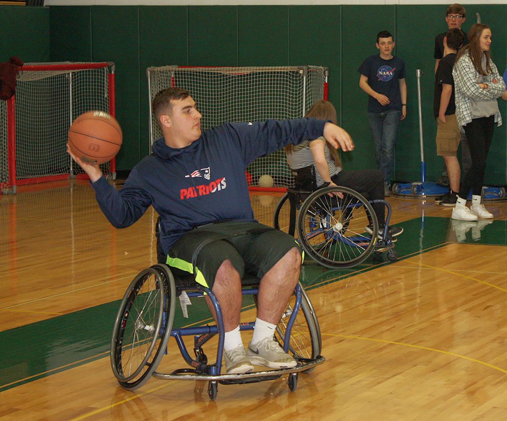 A male student uses a wheelchair to play basketball. 