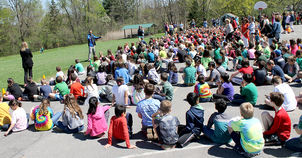 This is an image of students sitting on the blacktop