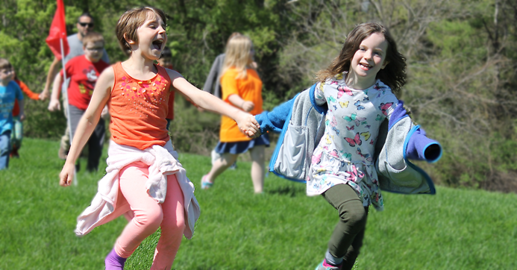 This is an image of two girls laughing and running