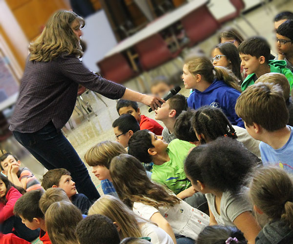 This is an image of Kate Messner talking to an elementary student