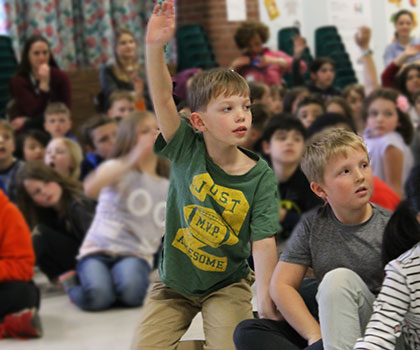 This is an image of a Mott Road student raising his hand