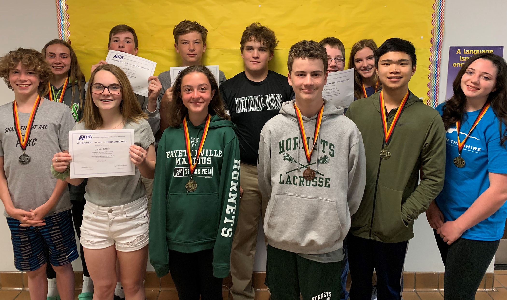 This is a group of sstudents standing together, holding certificates. 