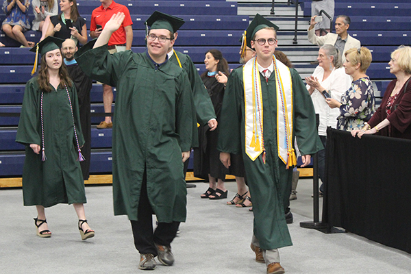 This is an image of two students walking during graduation