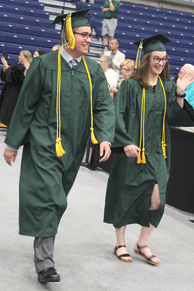 This is an image of two students walking at graduation