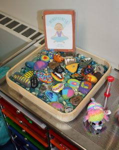 Painted rocks in a tray make a rock garden.