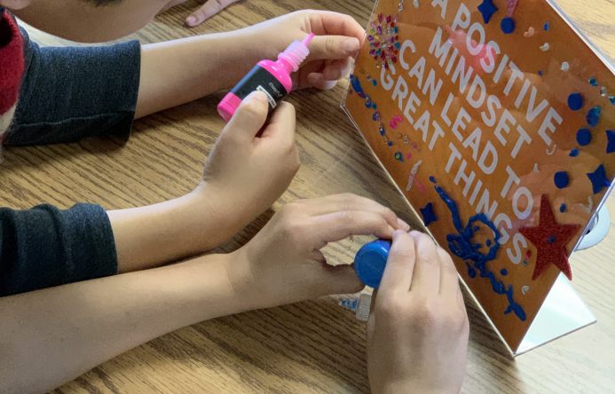 children's hands decorating frame.