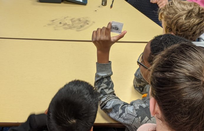 Student holding up fingerprint slide.