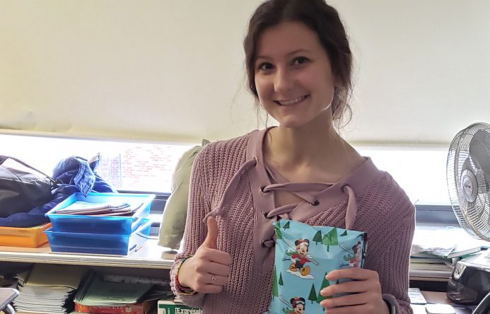 This is an image of a student holding a gift