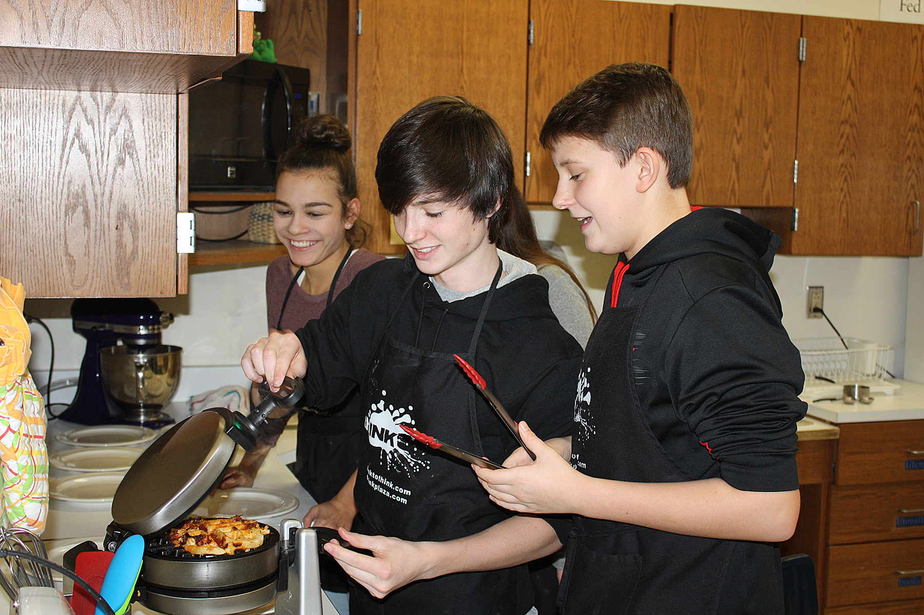 This is an image of three students making waffles