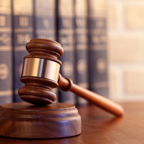 A gavel and books on a desk.