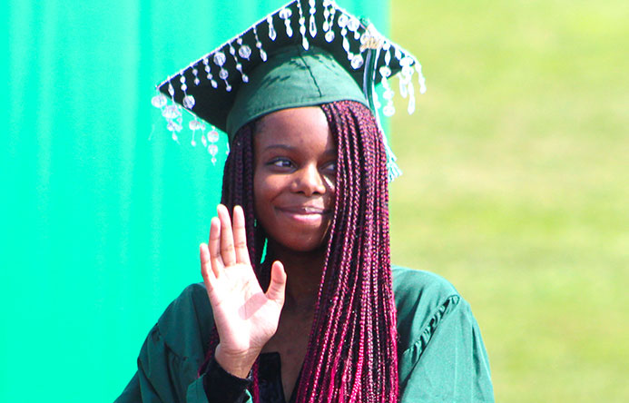 This is an image of a graduate waving