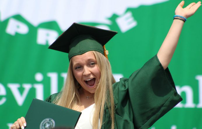 This is an image of a graduate waving