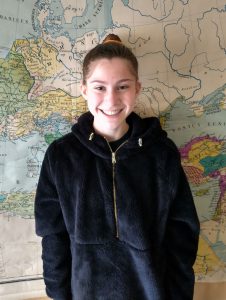 Student standing in front of map.