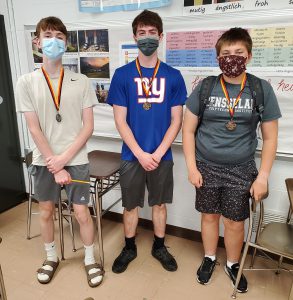 Three students standing side-by-side wearing face masks.