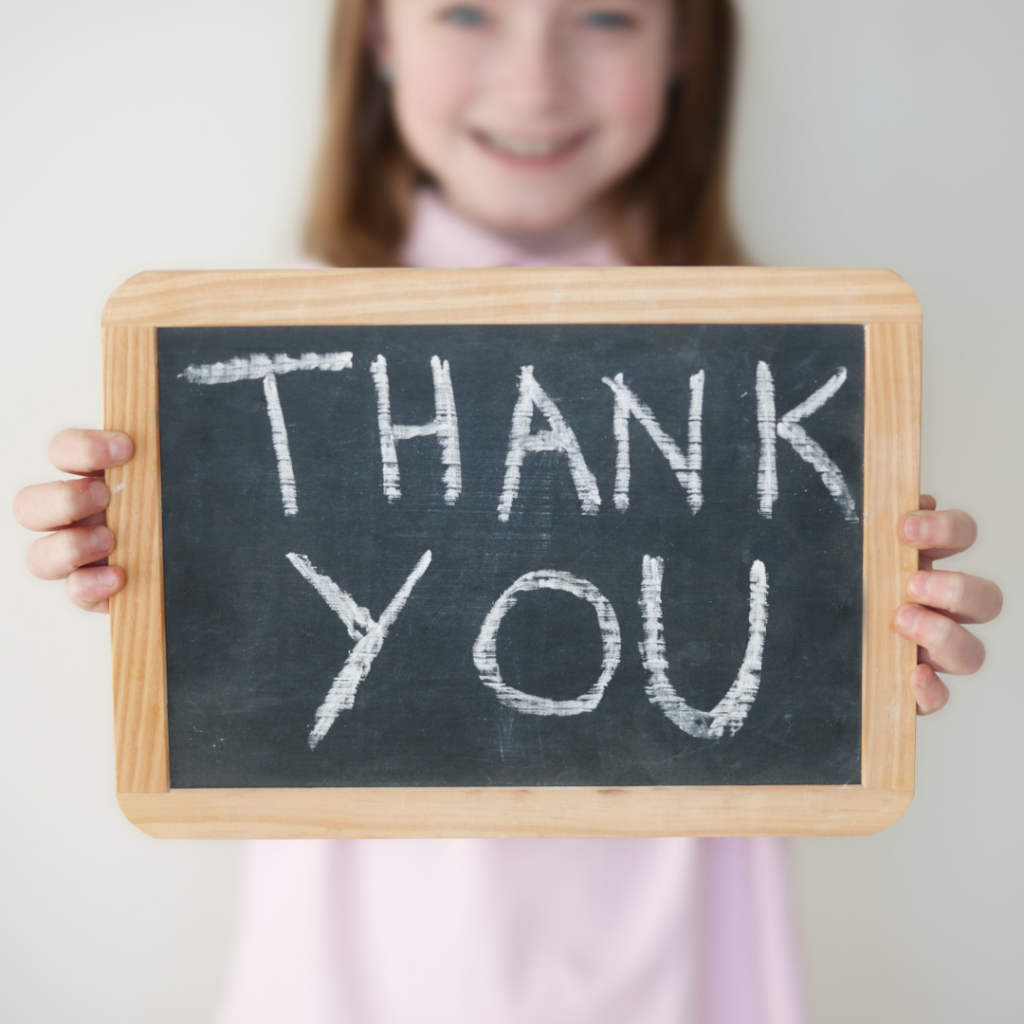 This is an image of a young child holding a chalkboard