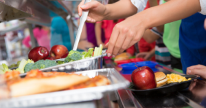 This is an image of food being served on trays on a lunch line.