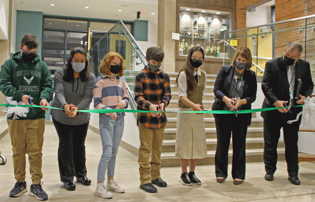 This is an image of students and staff standing in a line cutting a ribbon