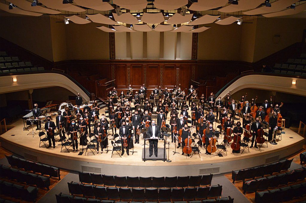 This is an overhead image of many student musicians standing on a stage ready to perform