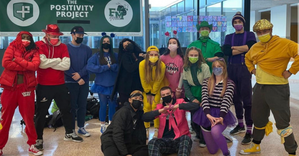 This is a group photo of several high school students who are wearing brightly-colored clothing