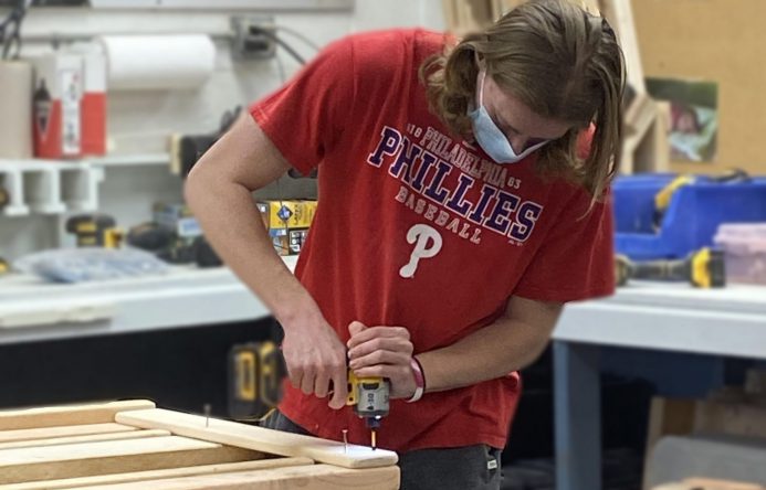 This is an image of a student drilling into a piece of wood