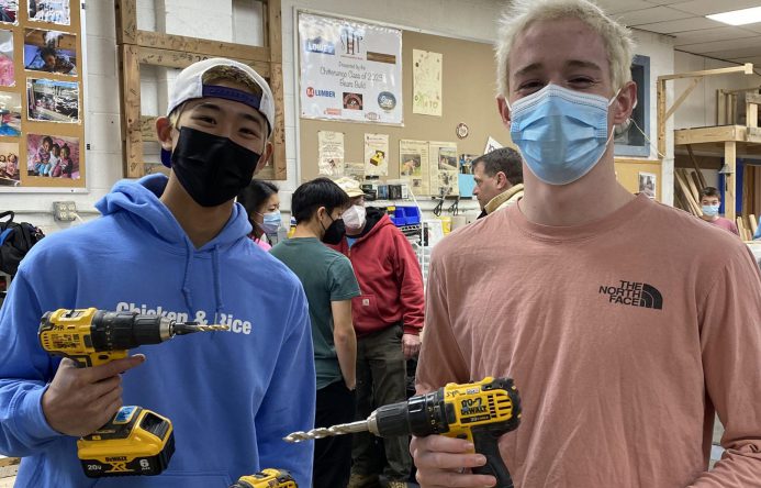 This is an image of two students holding power tools