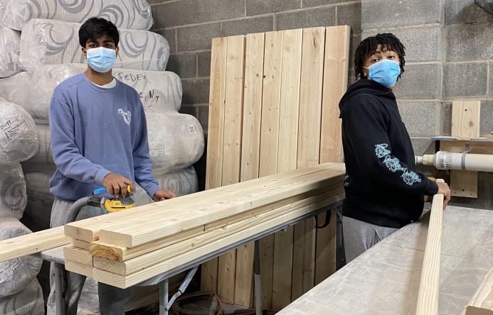 Two individuals working together to build a bunk bed.
