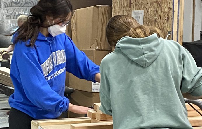 This is an image of two students building a bed together