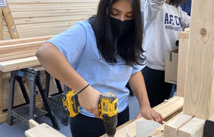 This is an image of a student using a drill